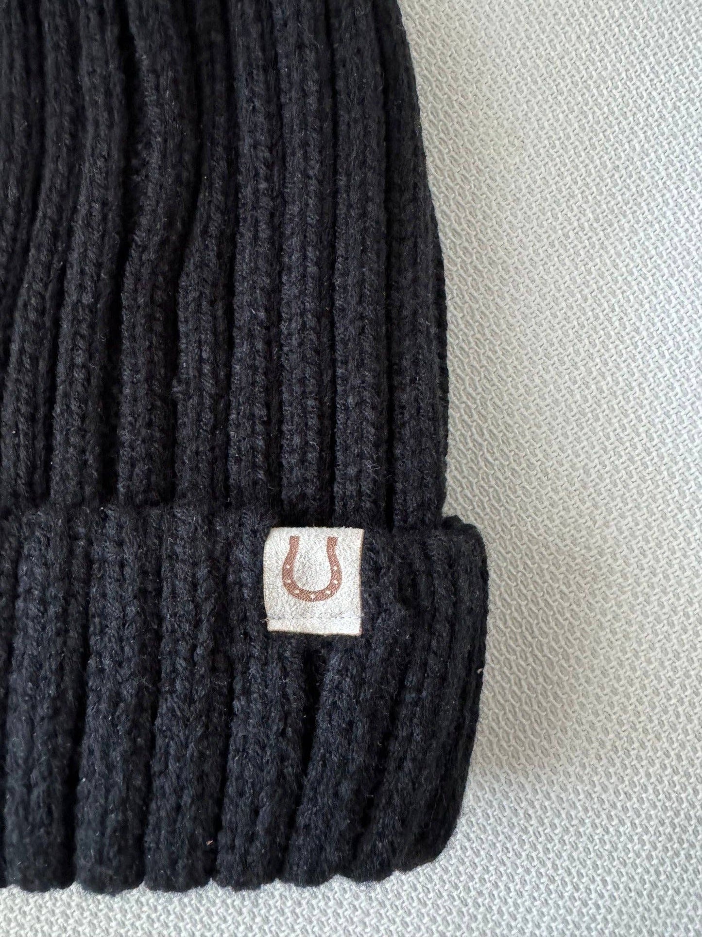 Black knit beanie with a horseshoe design on a light background. Equestrian Gift
