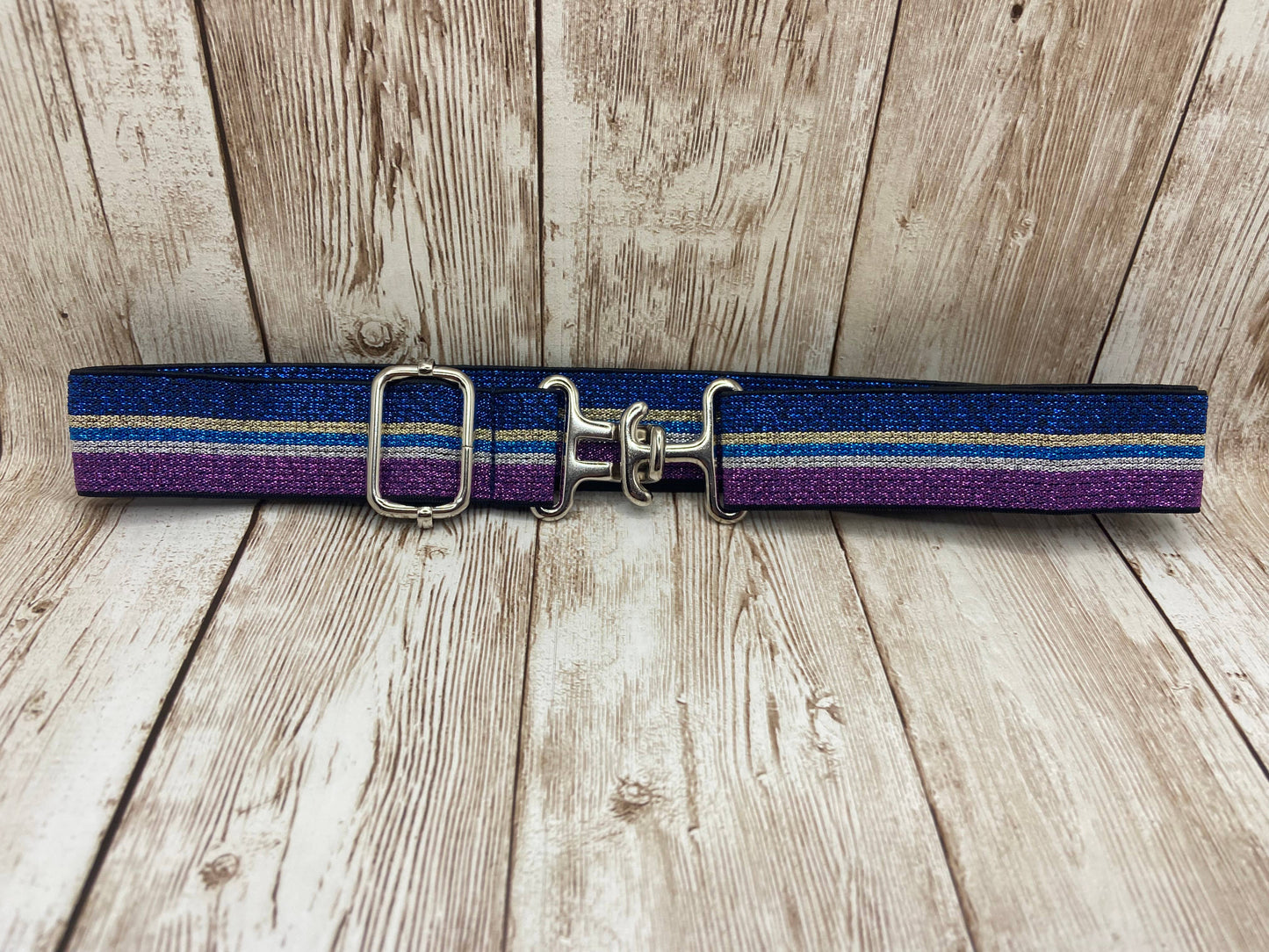equestrian youth belt with blue and purple stripes on a wooden surface