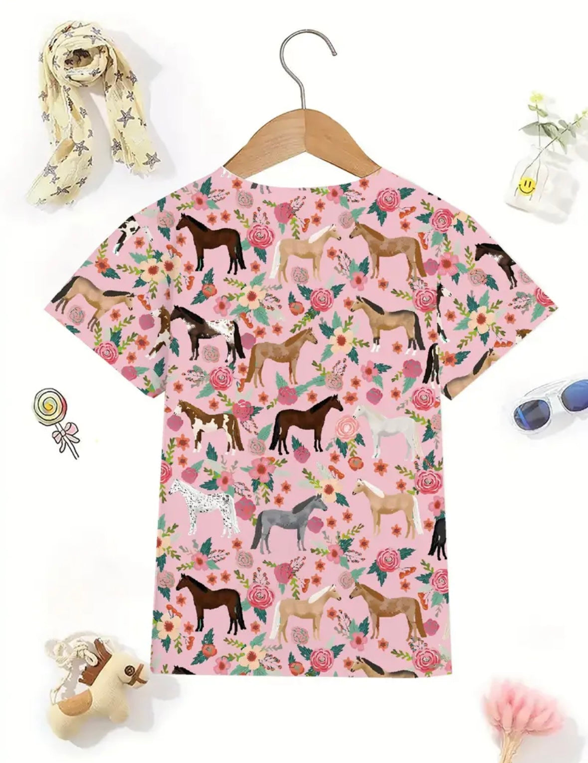 Youth-sized pink short-sleeve crewneck t-shirt featuring a horse graphic, designed for young equestrians.