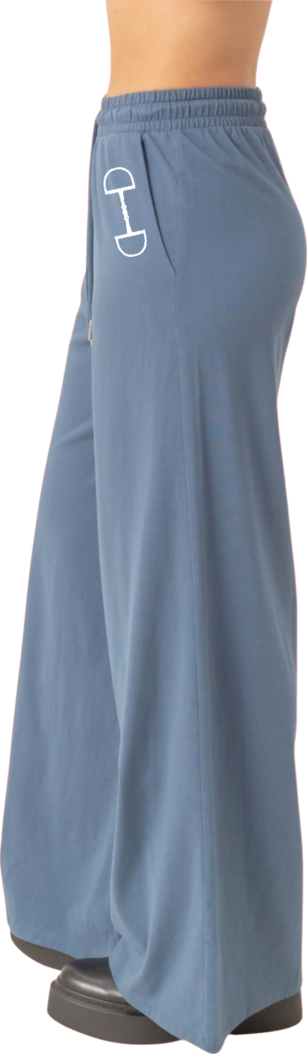 Blue wide leg equestrian lounge pants with a white logo on a person wearing them
