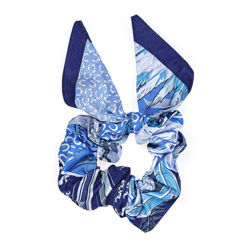 Blue and white horse patterned scrunchie with matching hair bow on a white background