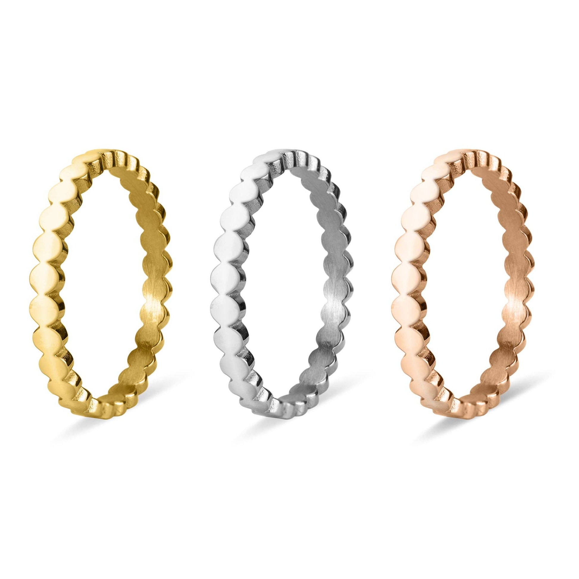 Three gold, silver, and rose gold beaded rings on a white background