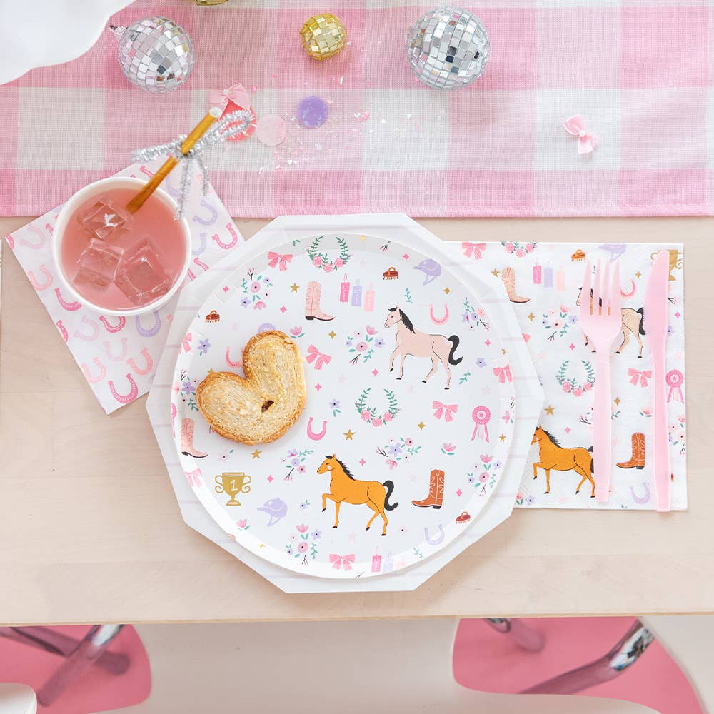 Children's party table setting with horse-themed plates, napkins, and a drink.