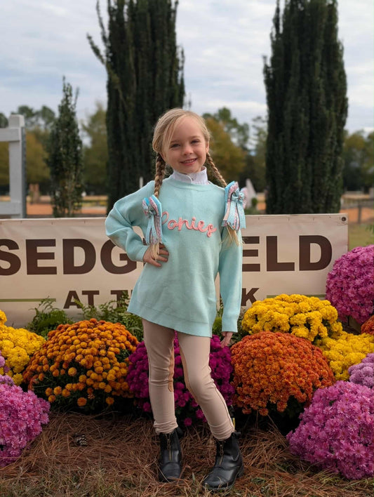 Teal sweater with "ponies" across the chest, front view