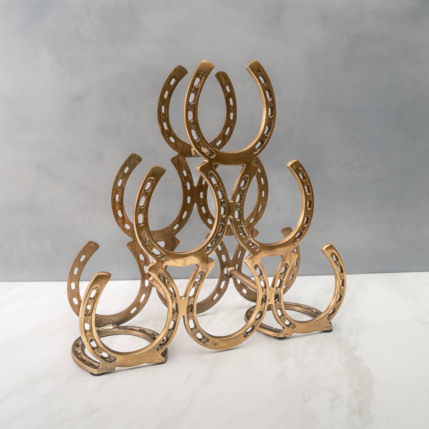 Equestrian-inspired 6-bottle wine rack featuring a textured horseshoe design in a classic brass-toned finish.