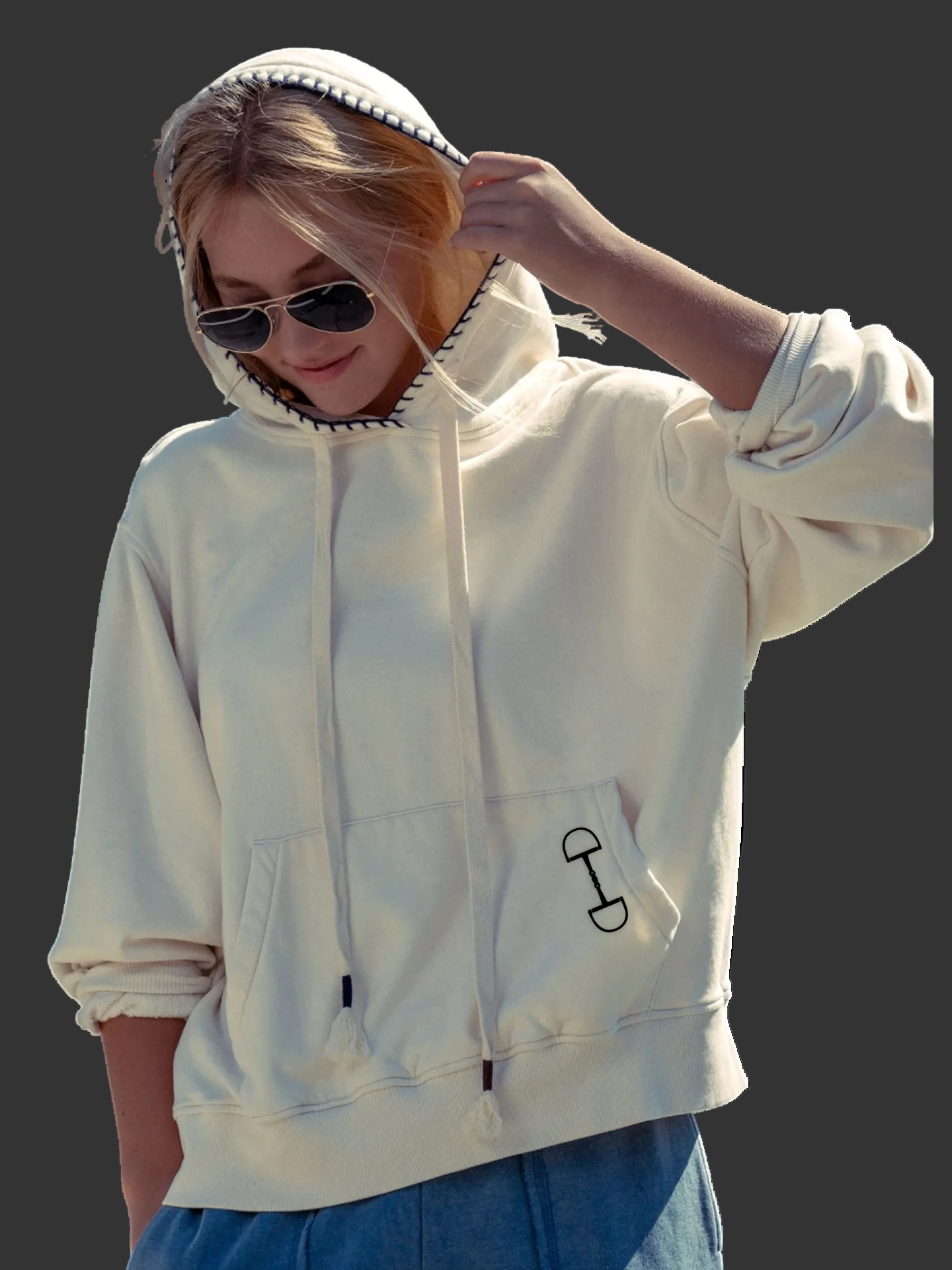 Person wearing a white hoodie with a small  equestrian design on the chest against a white background