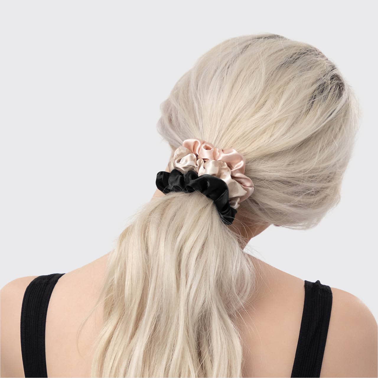 Classic black satin scrunchie for horseback riding, providing a gentle grip and friction-free hold under a riding helmet.