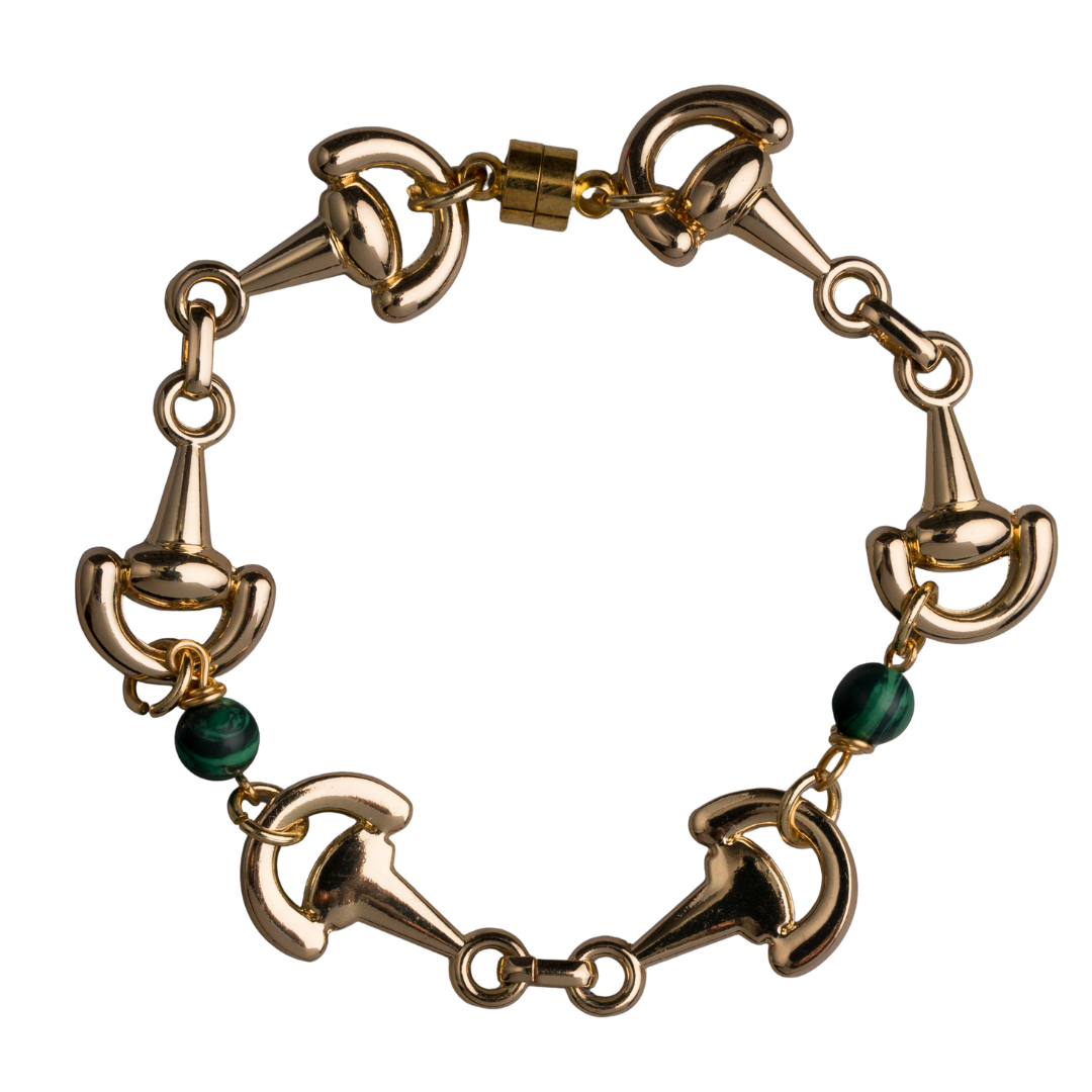 Gold bracelet with horse bit designs and green beads on a white background