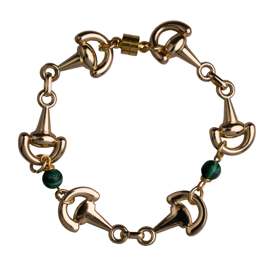 Gold bracelet with horse bit designs and green beads on a white background