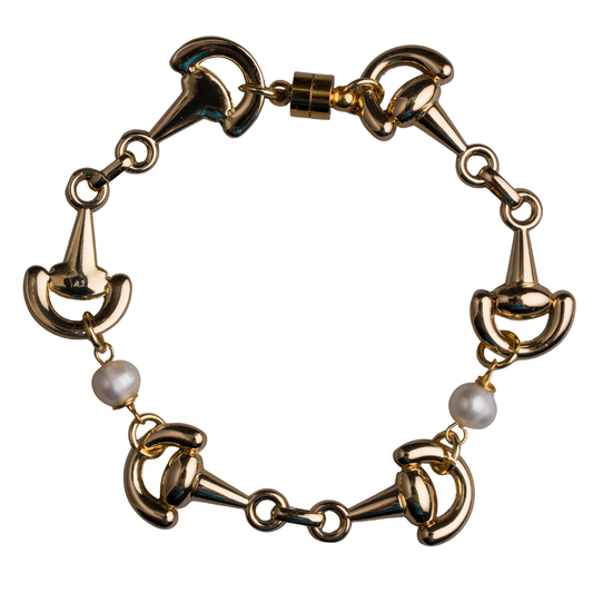 Gold bracelet with horsebit links and pearls on a white background