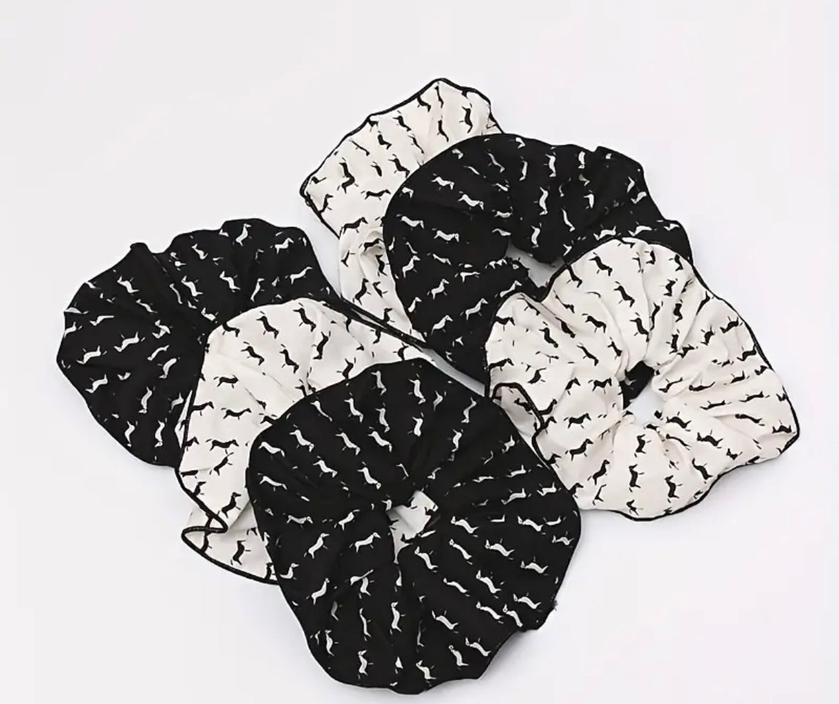 A collection of Pony Cotton Scrunchies in black and white with a geometric horse pattern on a white background.