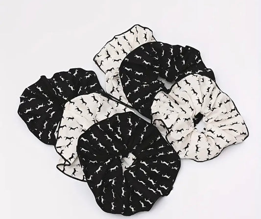 A collection of Pony Cotton Scrunchies in black and white with a geometric horse pattern on a white background.