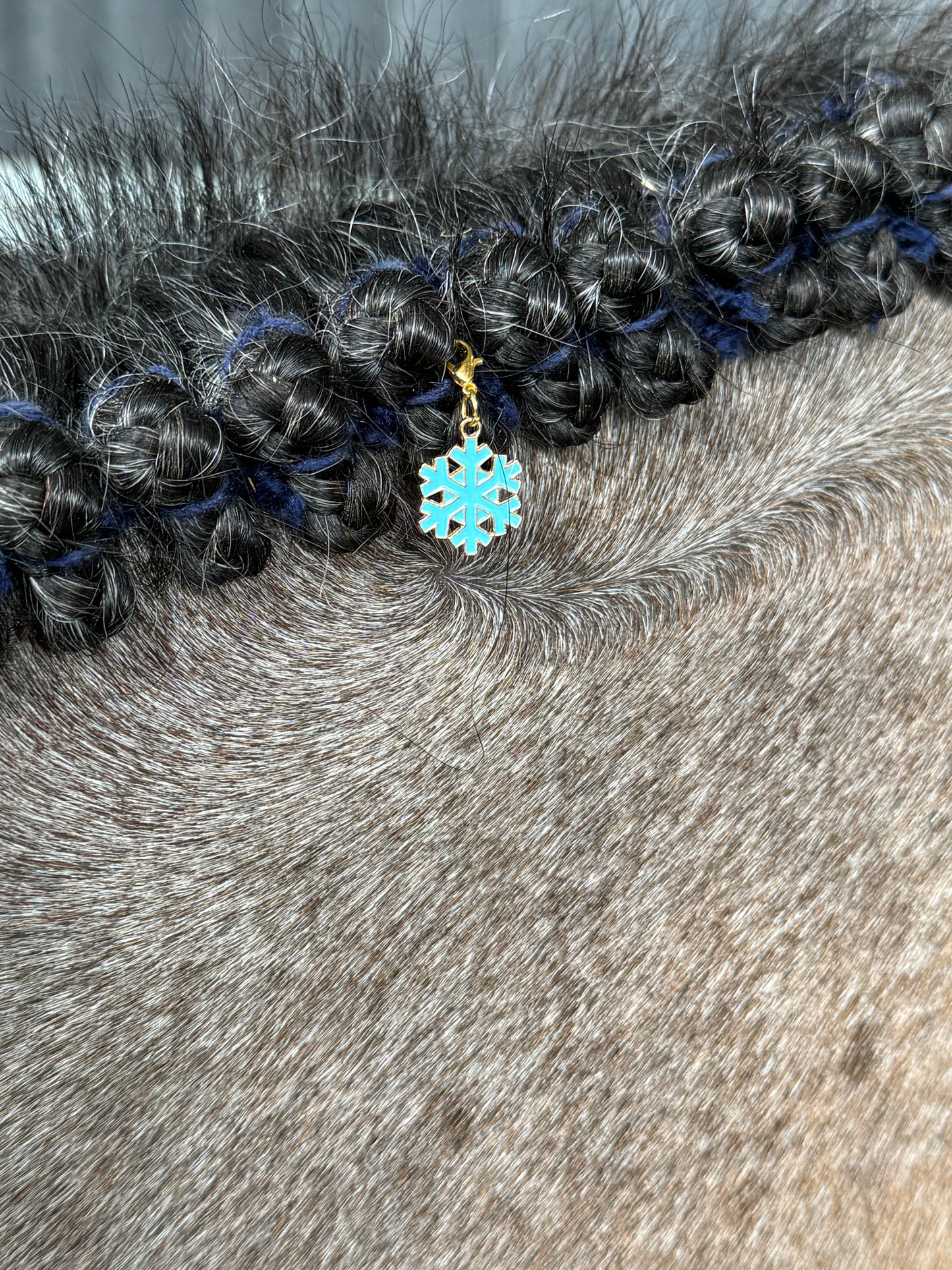 A festive collection of holiday-themed braid charms for horses, featuring seasonal colors and charms, displayed for use in manes and tails.