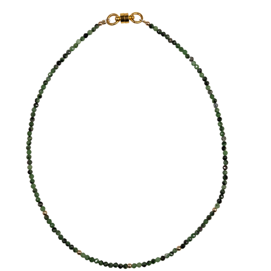 Green beaded necklace with a gold horsebit clasp on a white background