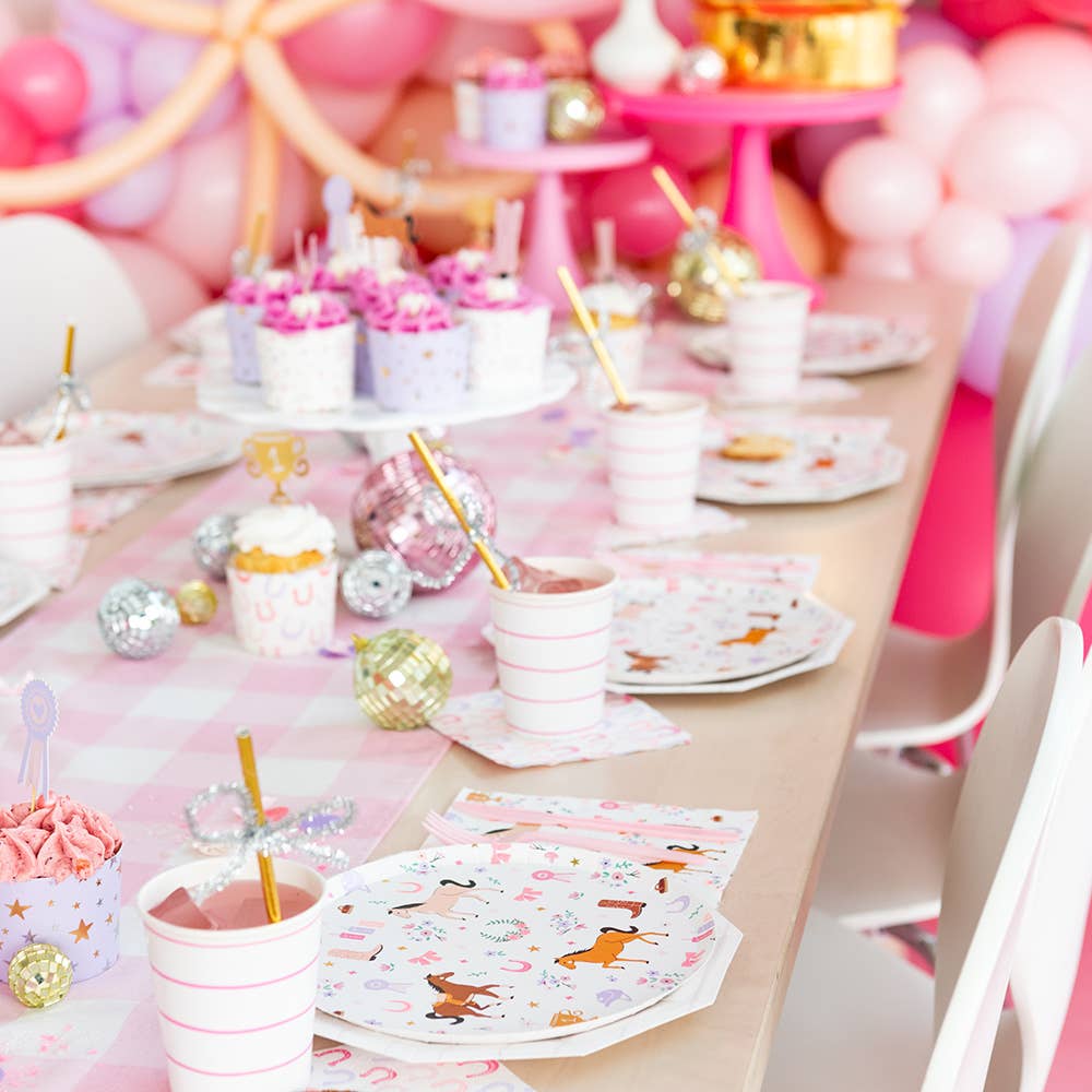 Decorative table setting with pink and gold party supplies, including plates, cups, and balloons.