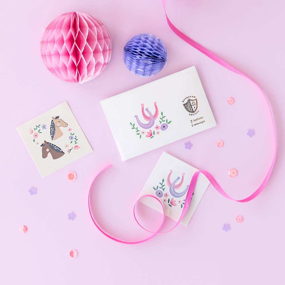 Three decorative cards with horse illustrations on a pink background with ribbons and honeycomb balls. Kids party gifts