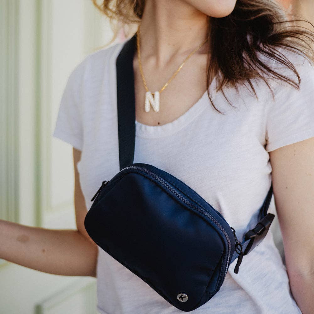 navy fanny pack worn by a stylish barn mom