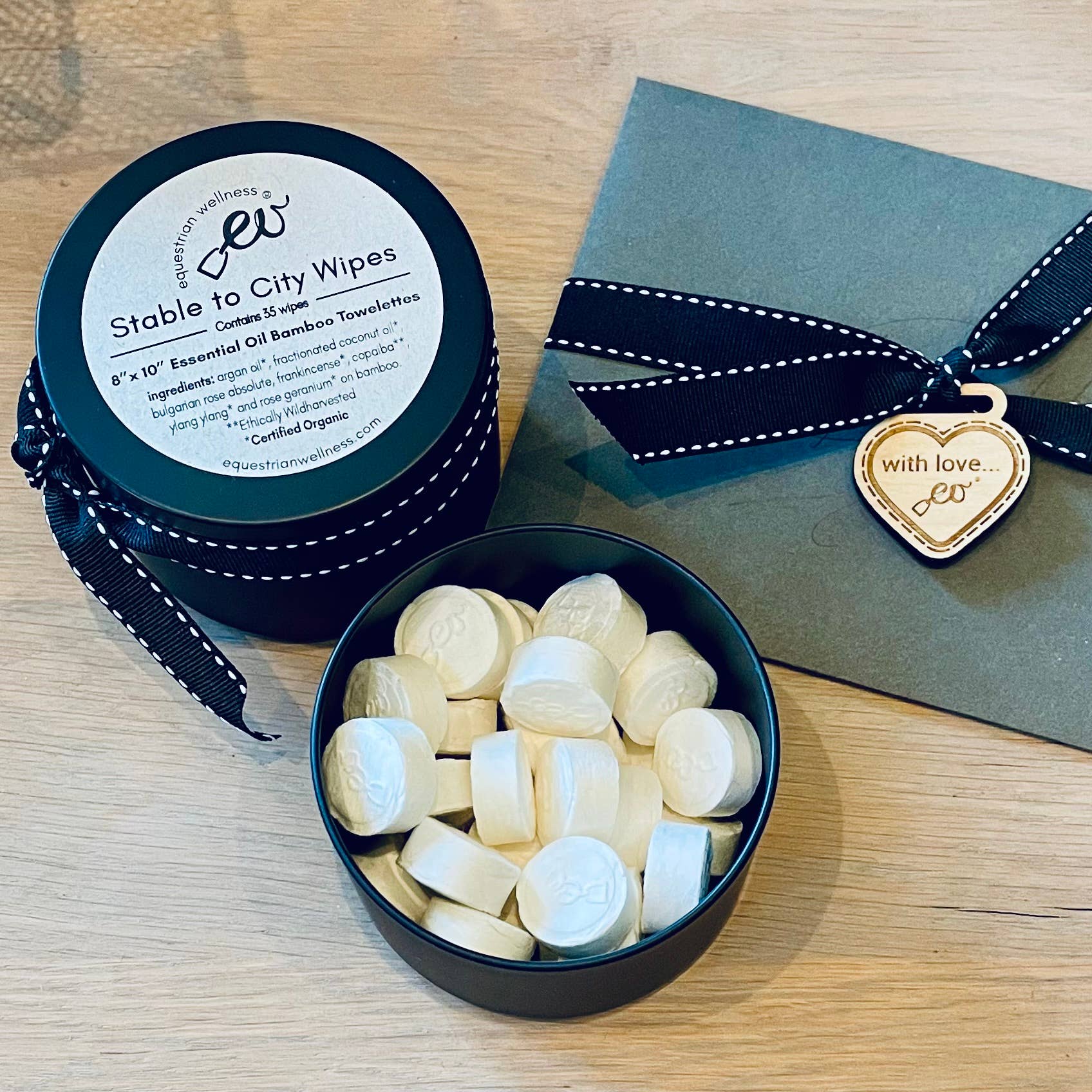Container of Stable to City ALL NATURAL Wipes with a heart-shaped tag on a wooden surface