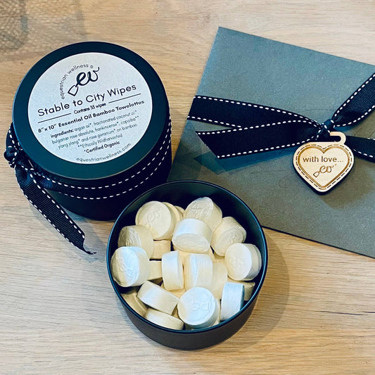 Container of Stable to City ALL NATURAL Wipes with a heart-shaped tag on a wooden surface