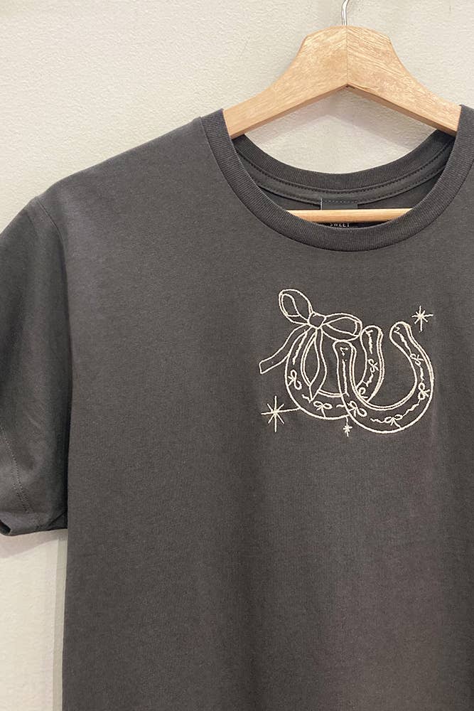 Gray t-shirt with a horseshoe design on a wooden hanger against a white background