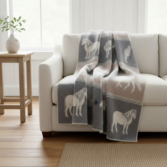 wool throw blanket in gray and white handmade with pony designs, one a white sofa