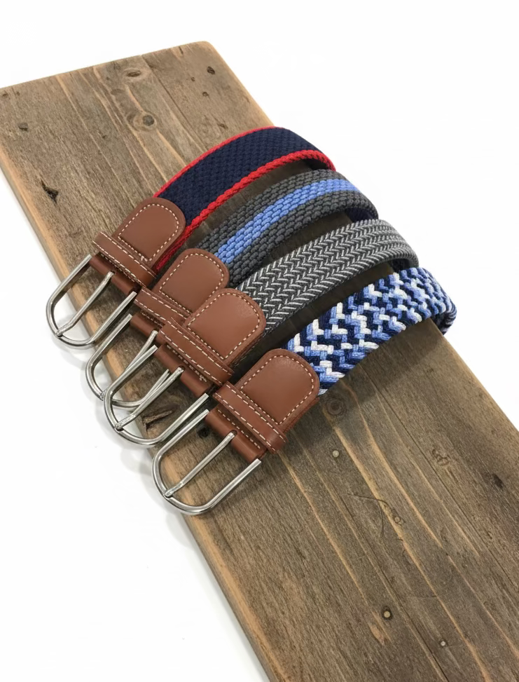 Set of woven belts with leather straps and metal buckles on a wooden surface