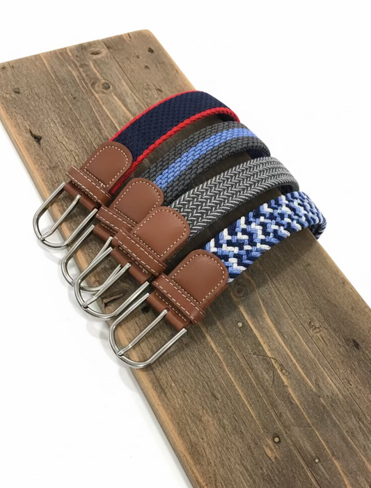 Set of woven belts with leather straps and metal buckles on a wooden surface